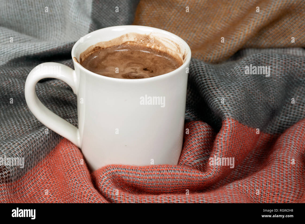 Chiudere fino a caldo di cioccolata in tazza bianca sulla calda coperta morbida Foto Stock
