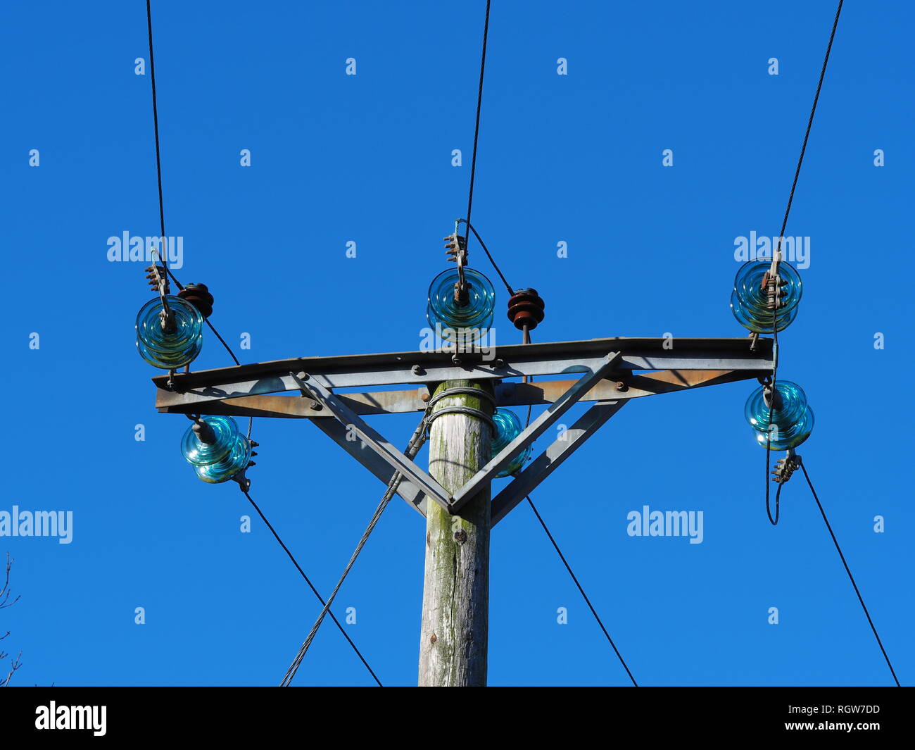 Tettuccio di linee di trasmissione di potenza elettrica con blue isolatori in vetro e un cielo azzurro sfondo Foto Stock