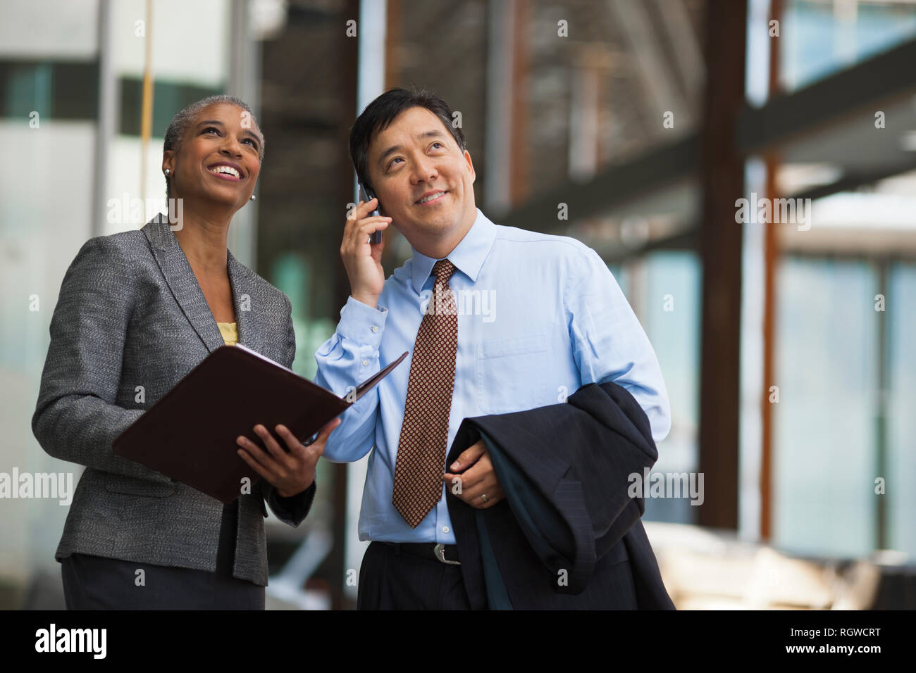 Due colleghi di lavoro per discutere i piani per un progetto su un sito in costruzione. Foto Stock