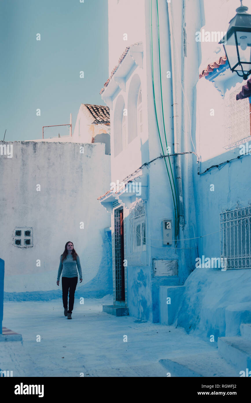 Giovane donna turistica a piedi su strada bianca a Chefchaouen, Marocco Foto Stock