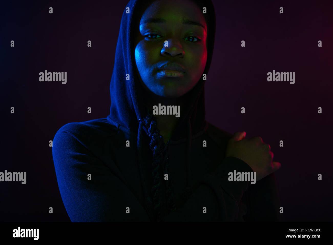 Ritratto colorato di un fresco donna con la pelle scura che indossa felpa con cappuccio Foto Stock