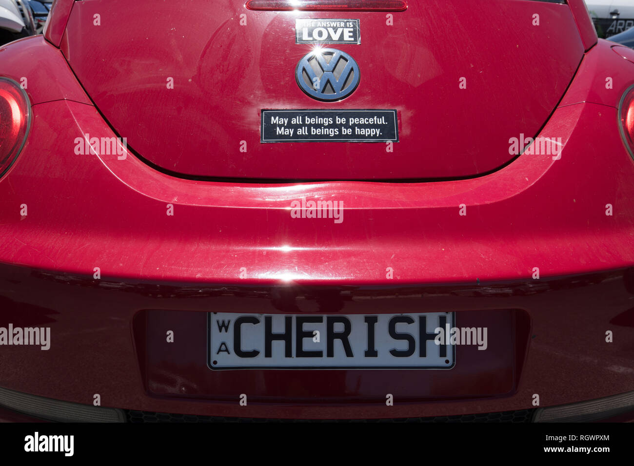 Numero privato piastra serbo ' ' e adesivi di segno di amore, di pace e di felicità su un rosso Volkswagen maggiolino, parcheggiato in spiaggia Whitfords, Perth, Western Foto Stock