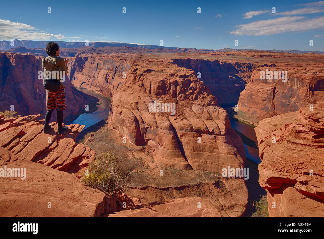 L'uomo escursionista guardando sopra il ferro di cavallo ansa del fiume Colorado in Pagina, Arizona Foto Stock