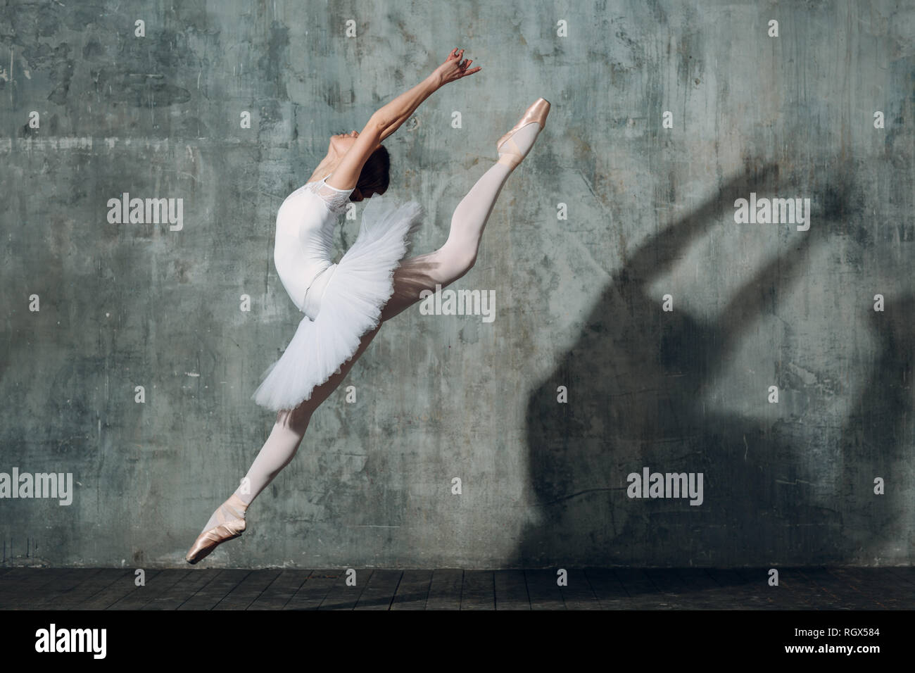 Jumping ballerina . Giovane donna bellissima ballerina, vestito in abiti professionali, pointe scarpe e white tutu. Foto Stock