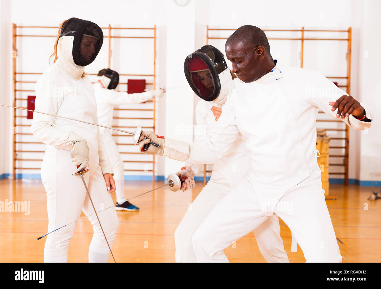 Gruppo di schermitori in allenamento di scherma, esercitare tecniche in battaglia Foto Stock