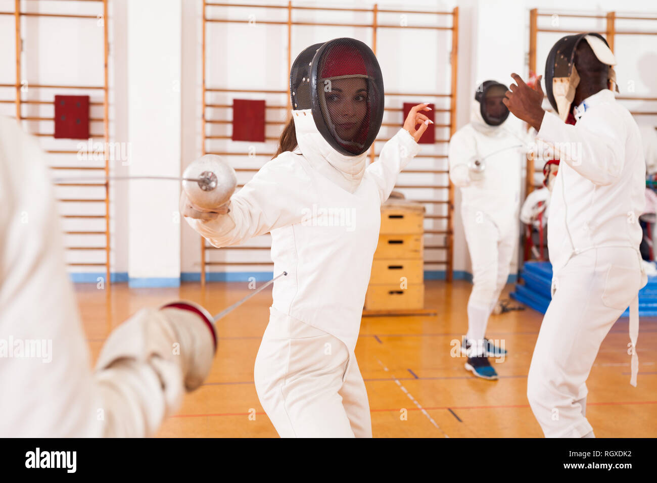 Gruppo di schermitori in allenamento di scherma, esercitando una delle tecniche in battaglia Foto Stock