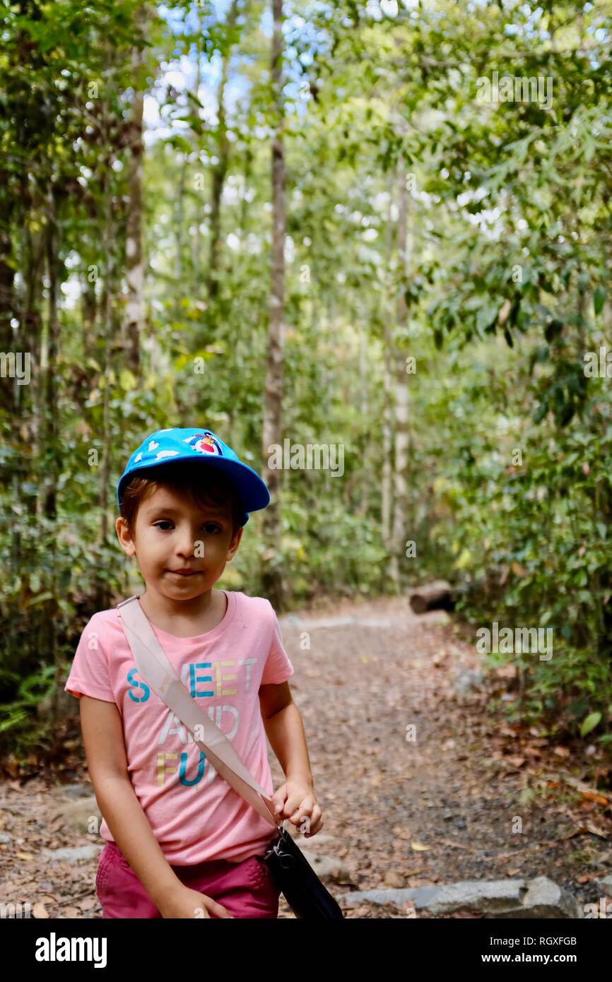 Un ritratto di una giovane ragazza carina in piedi su un percorso in una foresta, Finch Hatton, Queensland 4756, Australia Foto Stock