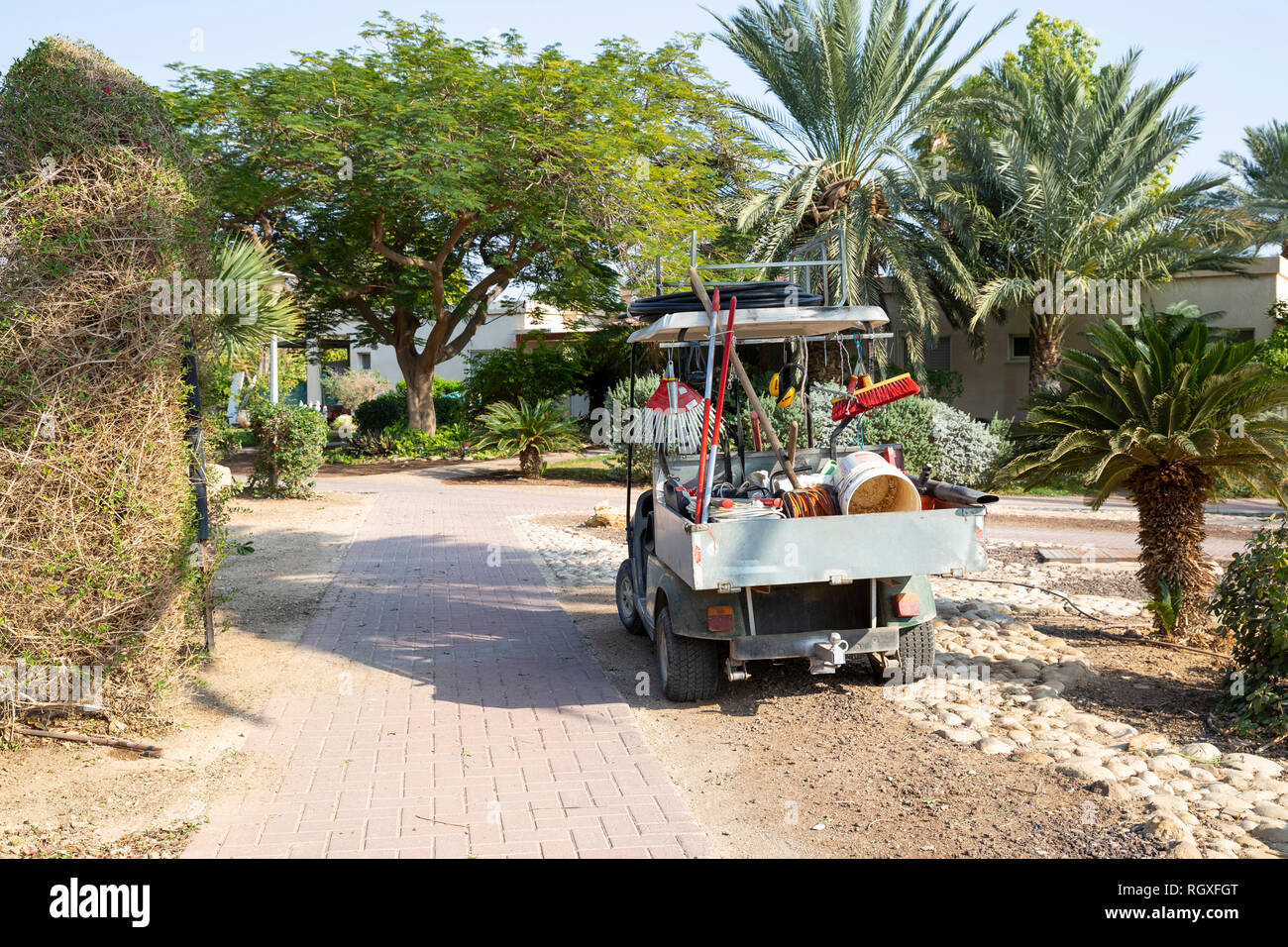 Un piccolo carrello di trasportare auto piena di attrezzi da giardino parco sul giardino botanico vicolo Foto Stock