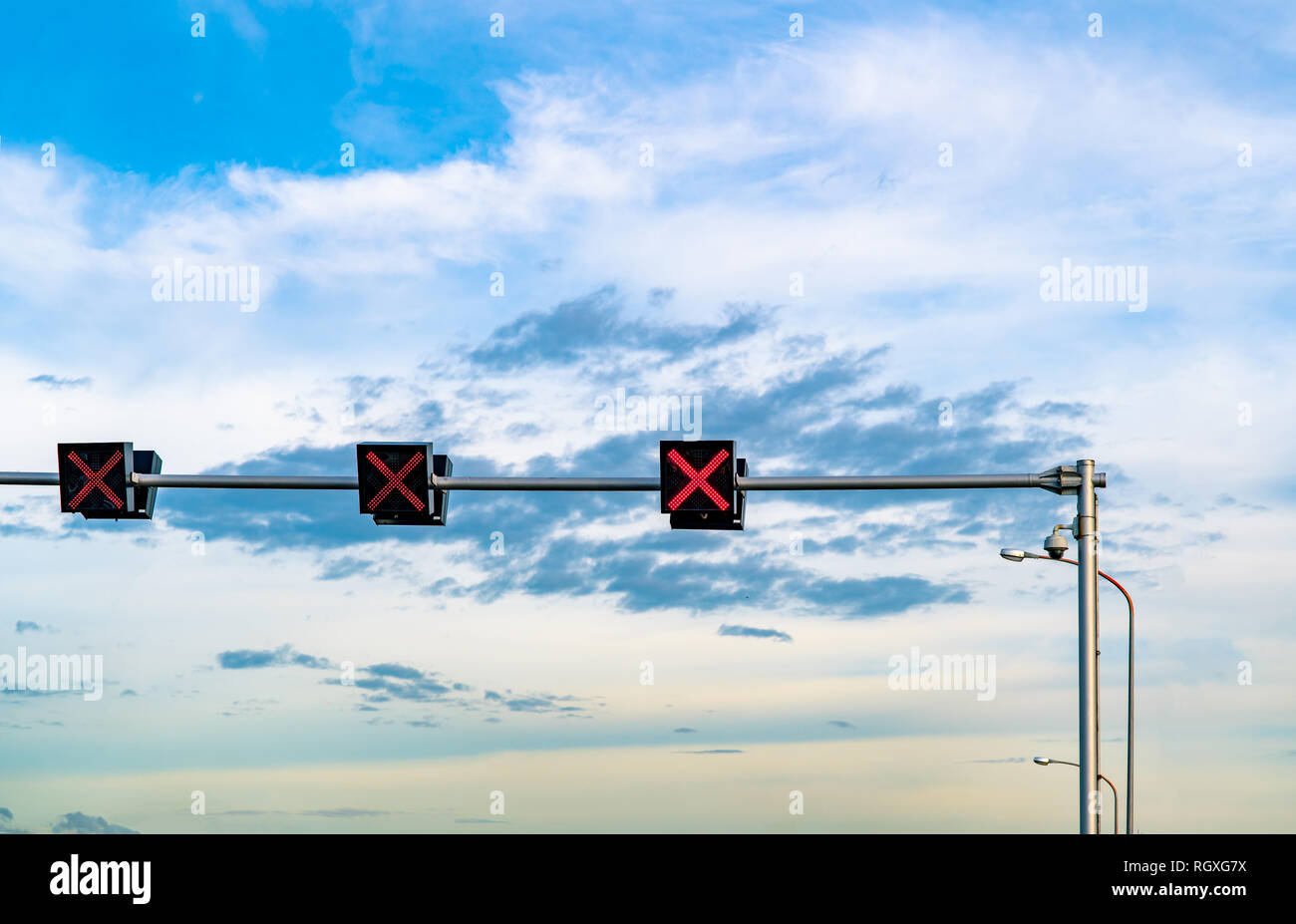 Segnale di traffico in luce con il colore rosso del segno a forma di croce sul cielo blu e nuvole bianche sfondo. Segno errato. Nessuna voce segno di traffico. La croce rossa di arresto di orientamento Foto Stock