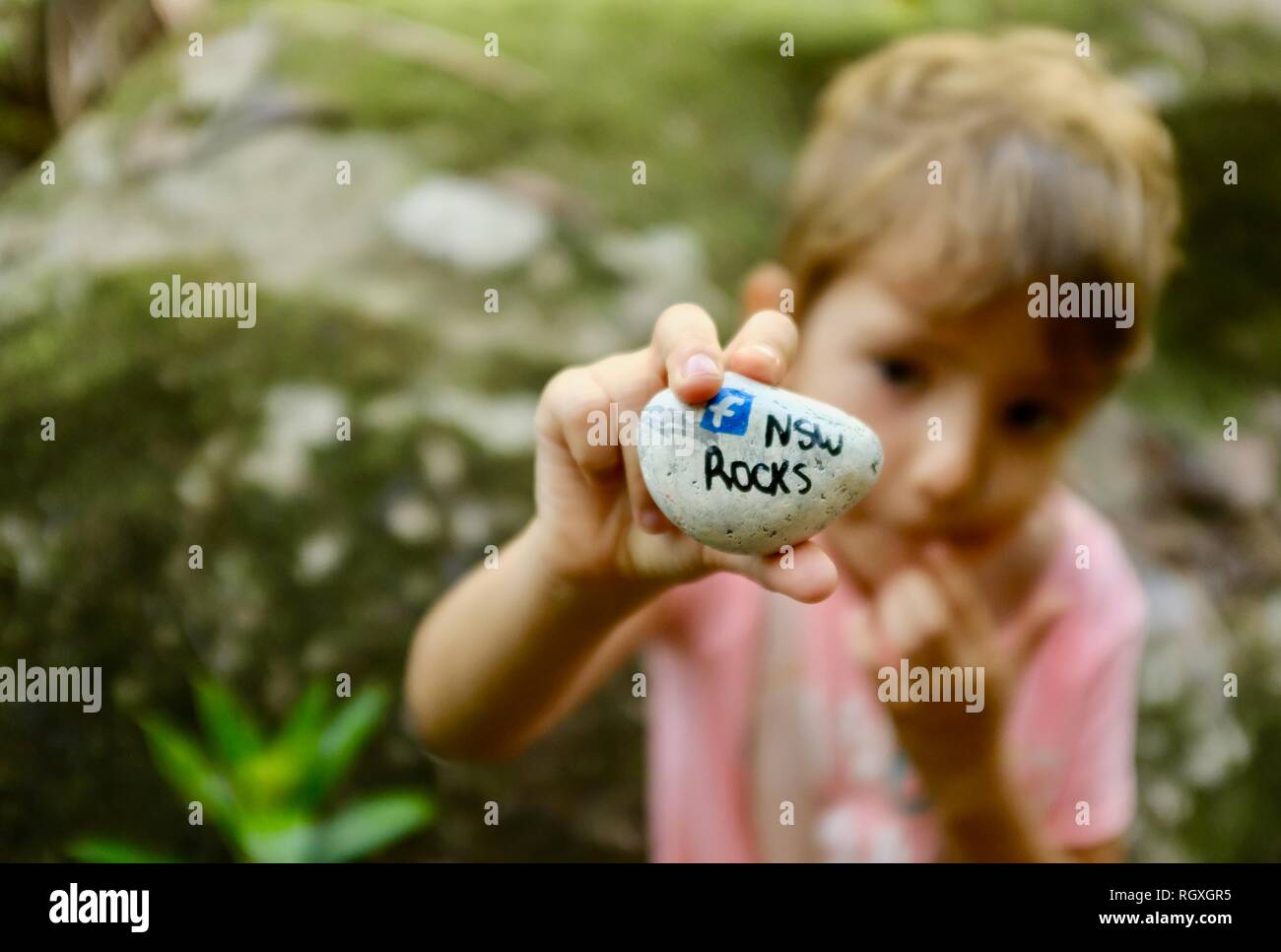 Bambino con in mano una NSW rocks rock ha trovato, Finch Hatton, Queensland 4756, Australia Foto Stock