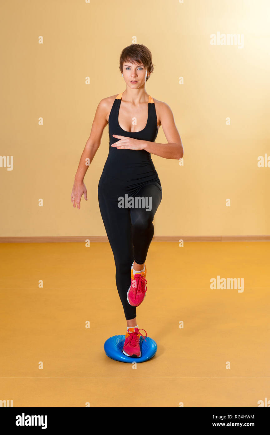 Sport focalizzato donna facendo esercizio aerobico in ambienti interni Foto Stock