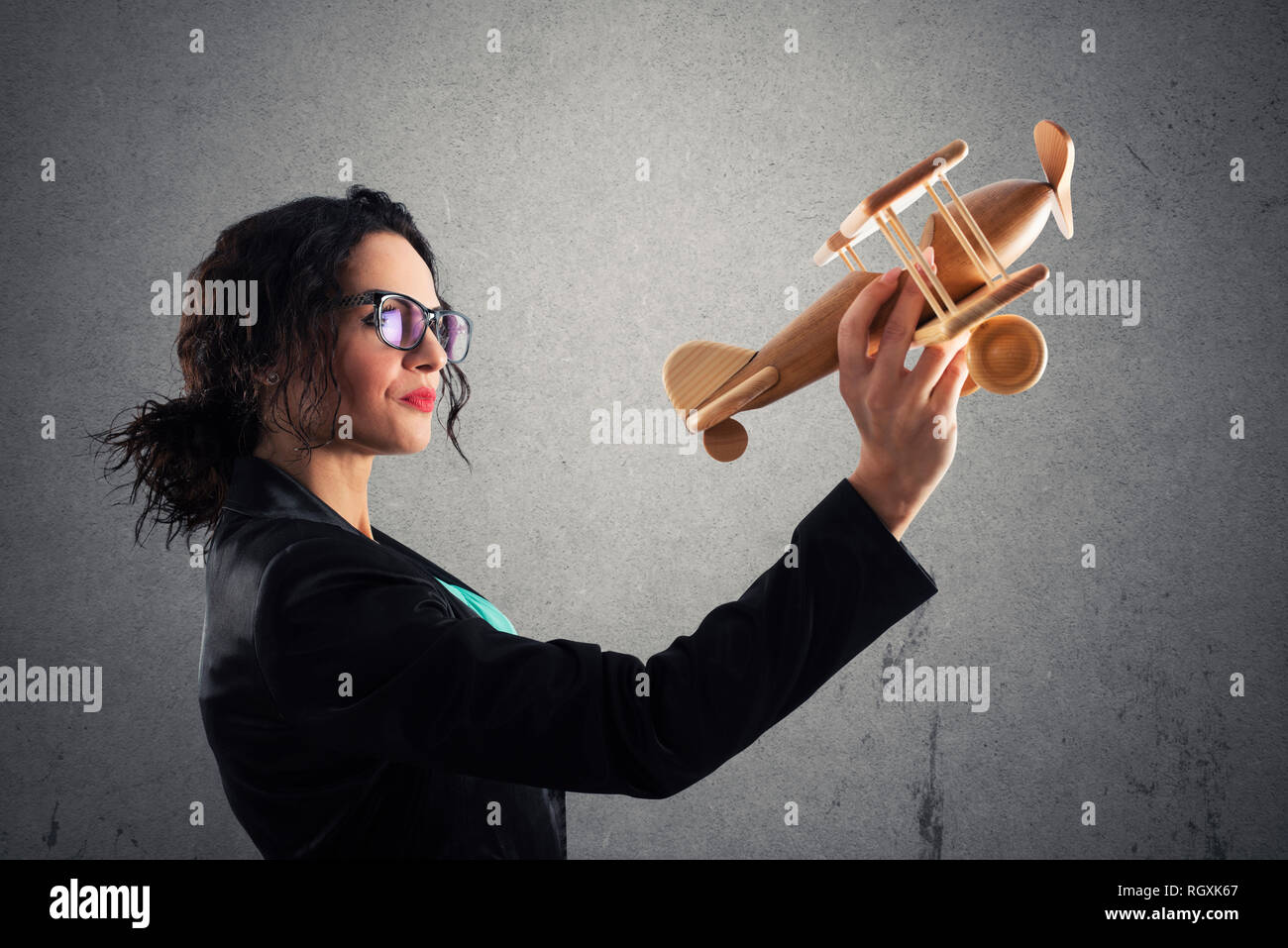 Imprenditrice giocare con un giocattolo aereo. Concetto di azienda startup e il successo del business Foto Stock