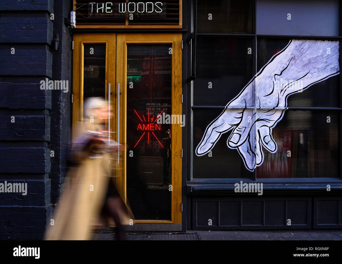 Ingresso al bar 'The Woods' con insegna Amen al neon e murale che punta la mano, Woman Walking, Shoreditch, Londra Foto Stock