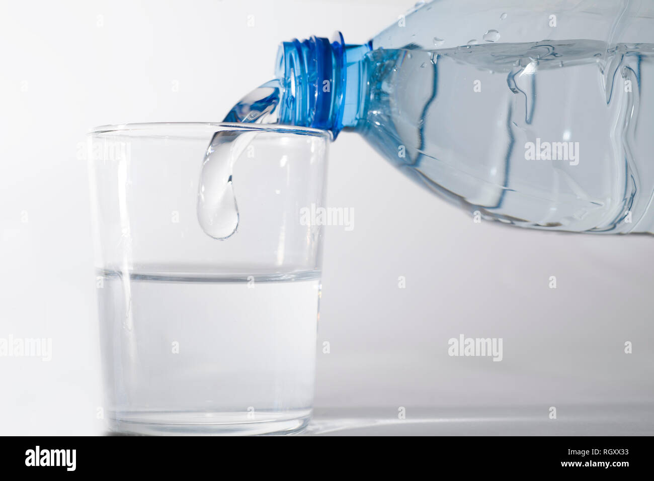 Riempire un bicchiere di acqua con una bottiglia di plastica Foto stock -  Alamy