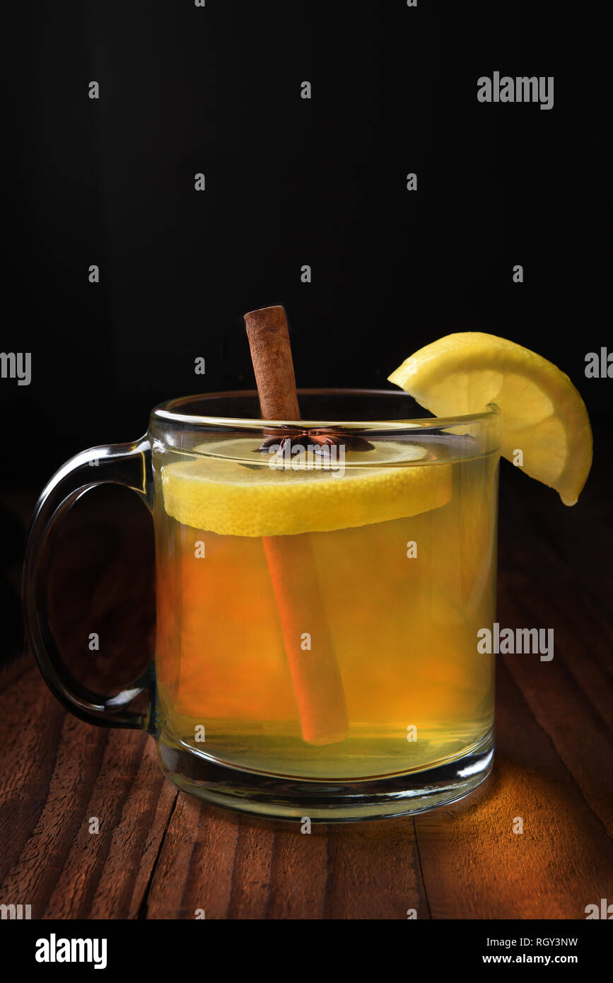 Primo piano di una calda Toody al buio su un tavolo di legno. Il whiskey, succo di limone e il miele da bere è spesso utilizzare per aiutare ad alleviare il freddo e sintomi influenzali. Foto Stock
