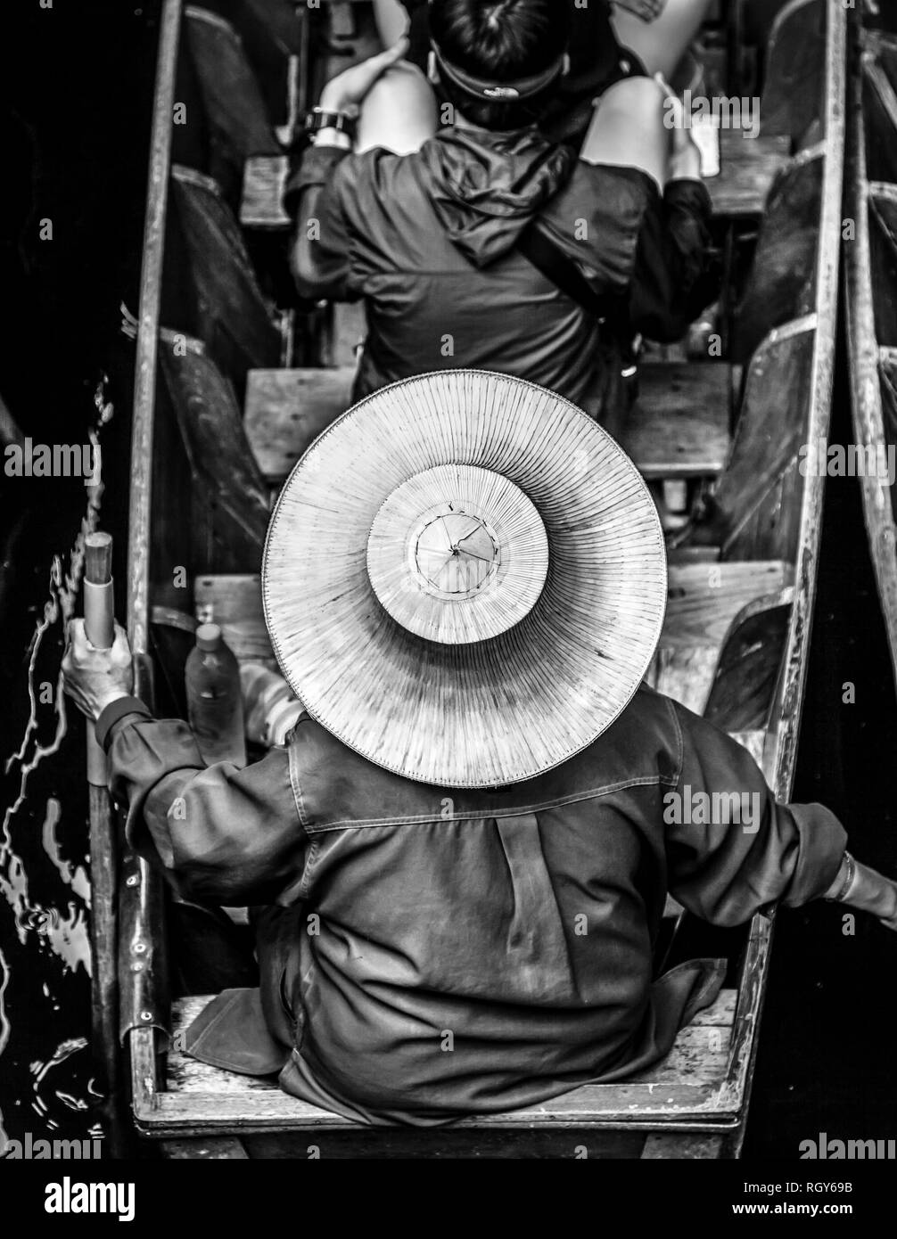 Thai donna che indossa un cappello di paglia si siede nella sua barca con i turisti al Mercato Galleggiante di Damnoen Saduak Foto Stock