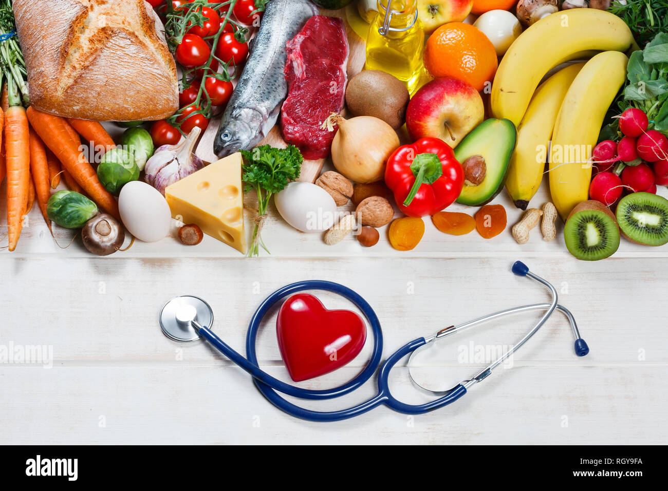 Uno stile di vita sano e il concetto di assistenza sanitaria. Cibo sano, di cuore e di uno stetoscopio Foto Stock