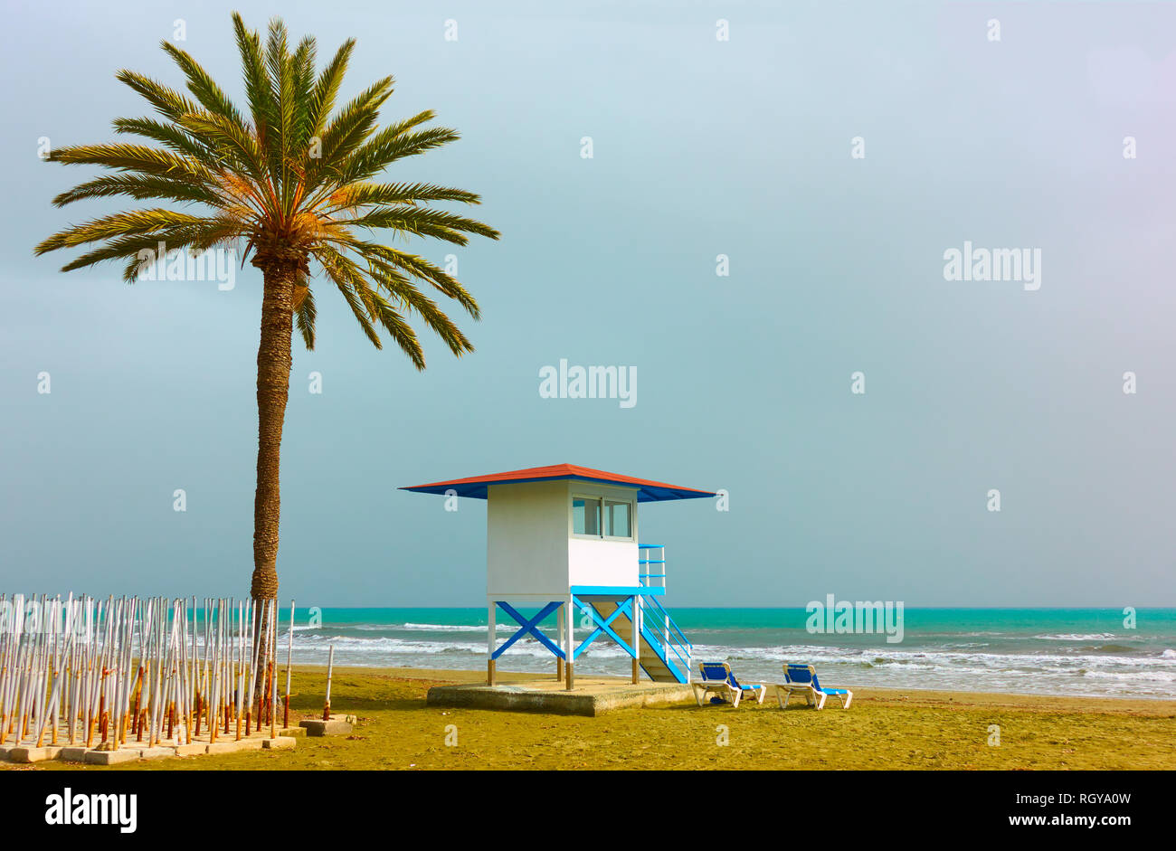 Spiaggia di sabbia con palme e vita torre di guardia in Larnaca, Cipro Foto Stock