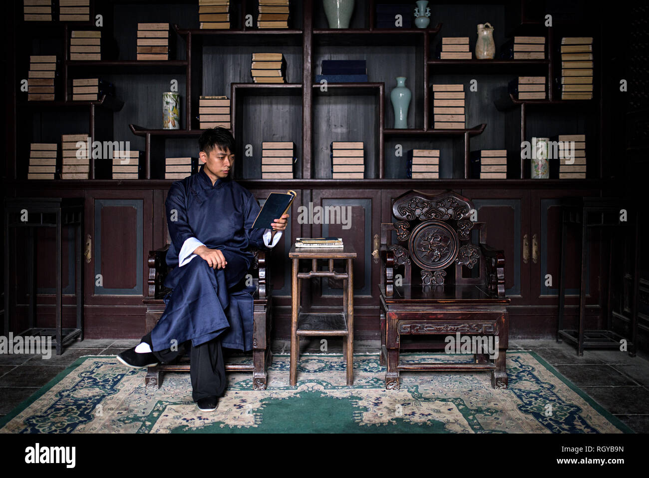Cinese di kung-fu master è la lettura di un libro a casa Foto Stock