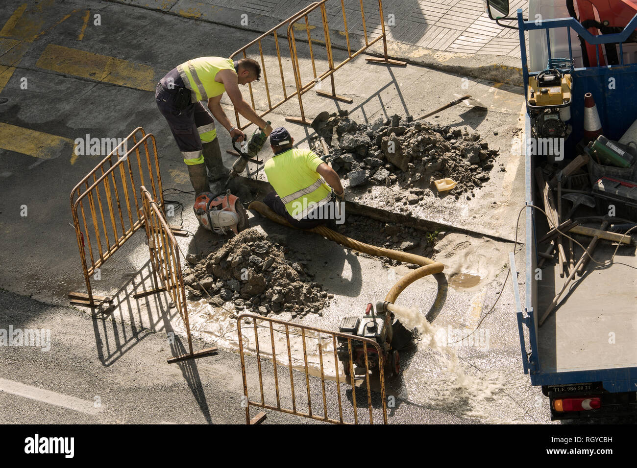 La Galizia, Spagna. 2 agosto 2018: lavoratori edili riparare la rottura di un tubo di acqua sulla strada Foto Stock
