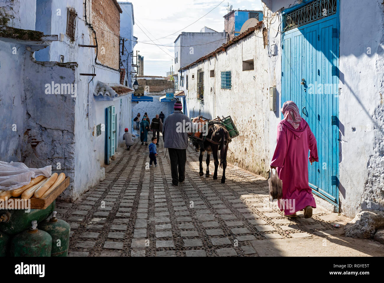 La gente del posto per fare shopping, lavorando e passeggiando per la città vecchia. Immagine di un giorno ordinario a Chefchaouen, Marocco Foto Stock
