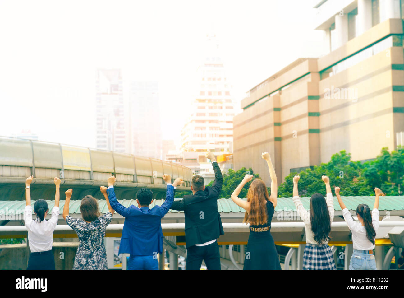Vista dal retro di business globale del lavoro di squadra alzare le mani in alto,hanno spazio per idea Foto Stock