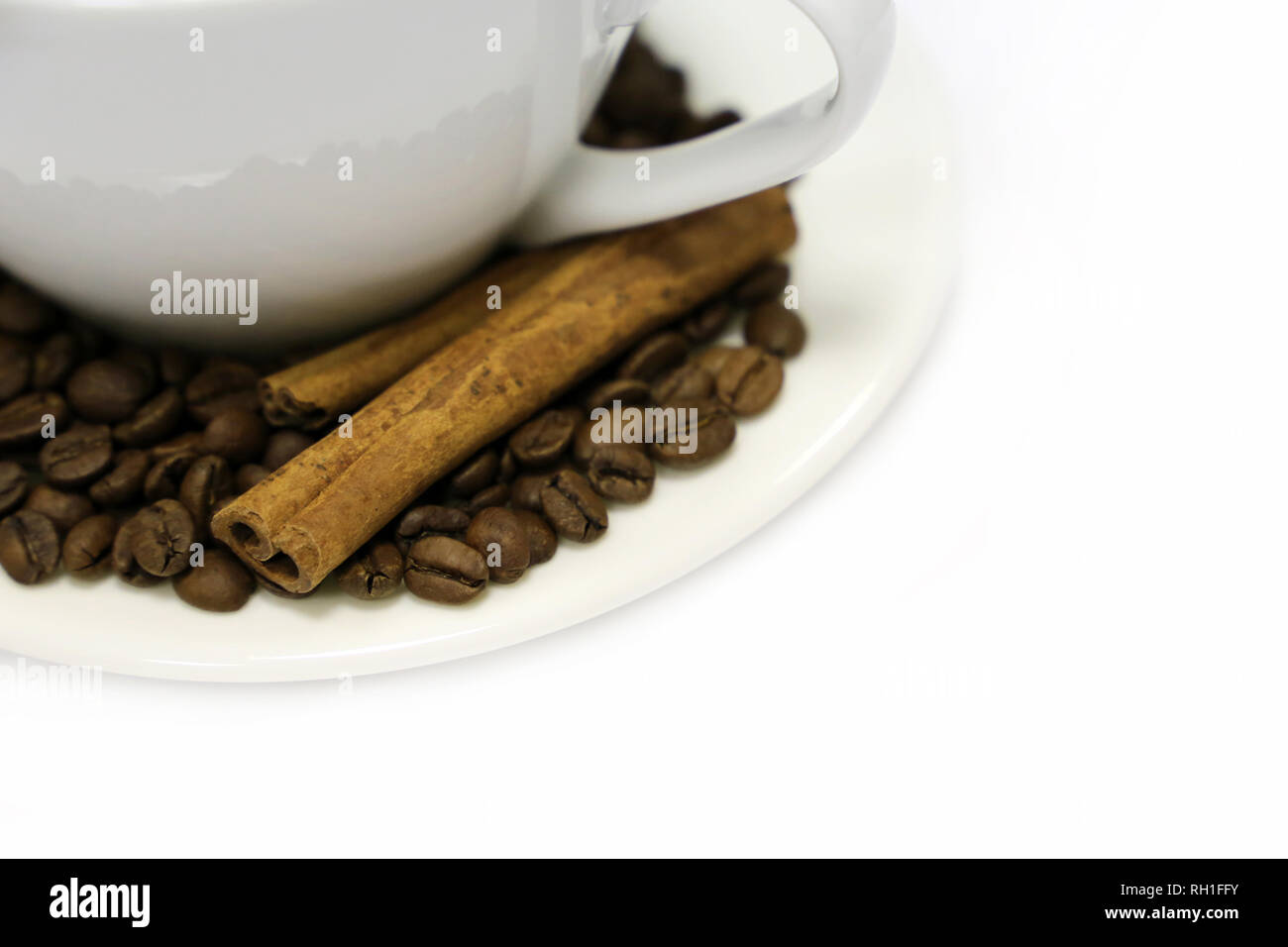 Tazza da caffè, caffè torrefatto in grani e bastoncini di cannella, isolato su sfondo bianco. Concetto di colazione, mattina felice Foto Stock