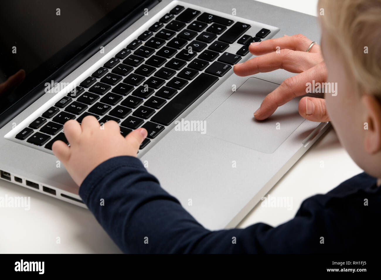 Un genitore e un bambino che interagiscono con un notebook, evidenziando l'uso della tecnologia e le esperienze di apprendimento precoce. Foto Stock