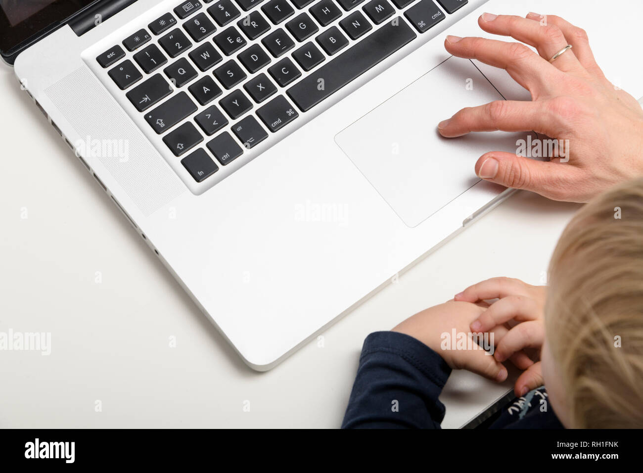 Un genitore e un bambino che interagiscono con un notebook, evidenziando l'uso della tecnologia e le esperienze di apprendimento precoce. Foto Stock
