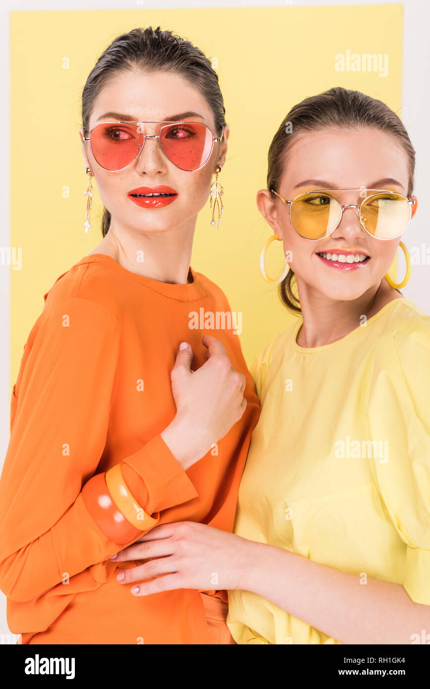 Messa a fuoco selettiva di belle ragazze eleganti in occhiali da sole in posa con ribalta sullo sfondo Foto stock Alamy