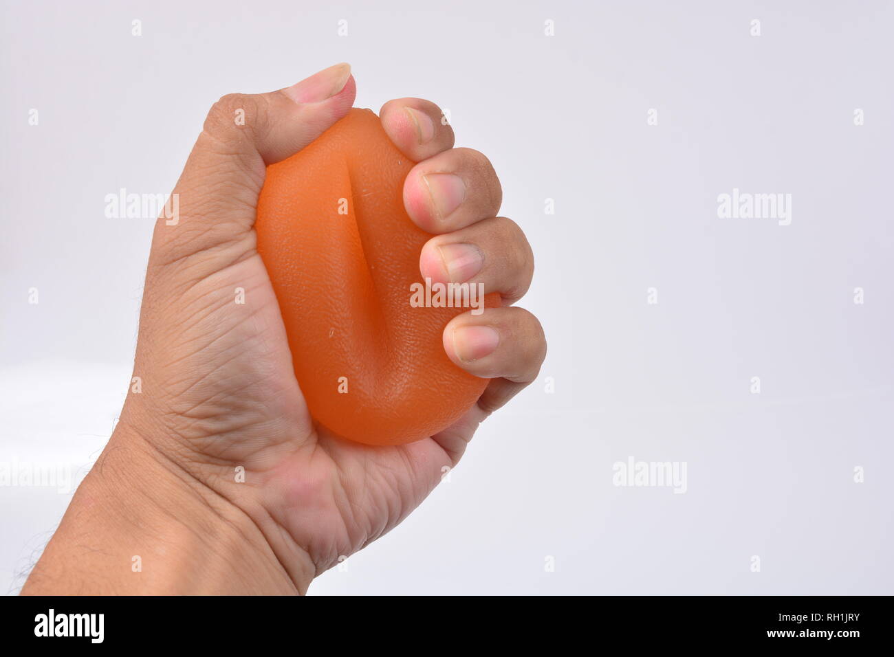Le mani di un uomo la spremitura di una palla a mano la terapia con forza Squeeze sfera di presa Foto Stock