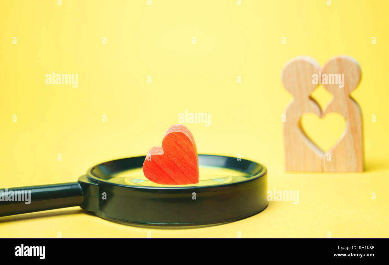 Cuore, lente di ingrandimento e un paio in amore. Il concetto di famiglia e i problemi di perdita di sentimenti per il vostro amato. Famiglia di consultazione psicologo Foto Stock
