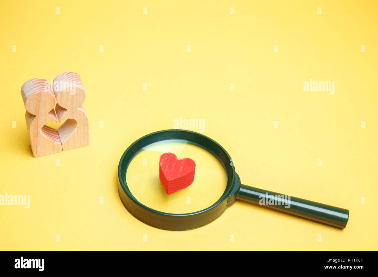 Cuore, lente di ingrandimento e un paio in amore. Il concetto di famiglia e i problemi di perdita di sentimenti per il vostro amato. Famiglia di consultazione psicologo Foto Stock