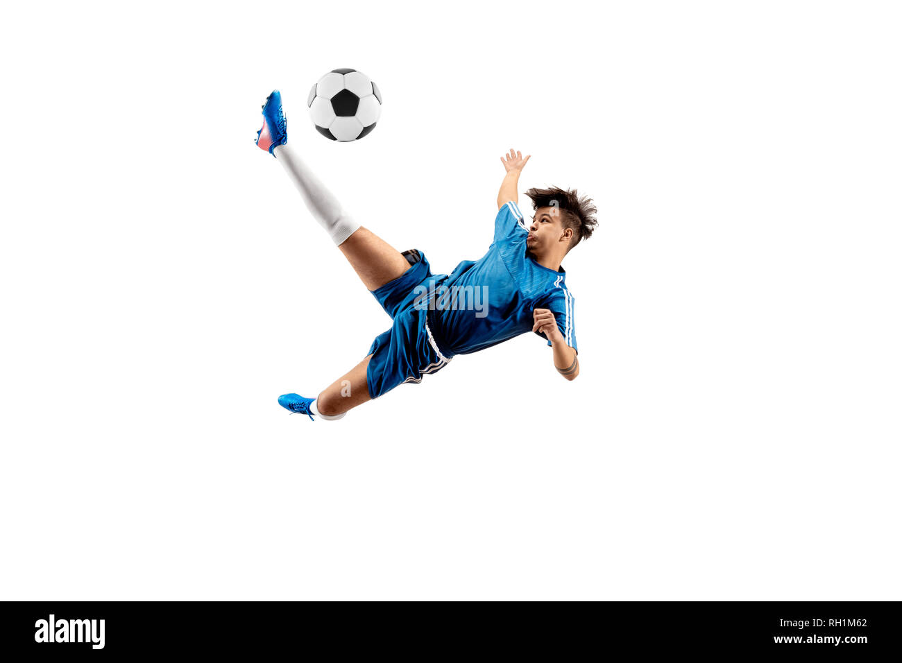 Ragazzo con pallone da calcio facendo volare kick, isolato su bianco. football giocatori di calcio in movimento su sfondo per studio. Montare jumping Boy in azione, jump, movimento al gioco. Foto Stock