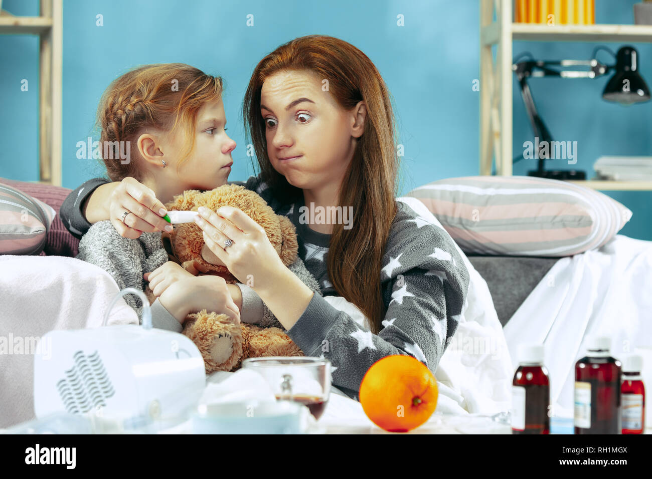 Malata con la figlia a casa. Il trattamento a casa. Lottare con una malattia. Delle cure mediche. Famiglia iIlness. L'inverno, influenza, salute, il dolore, la paternità, il concetto di relazione. Relax a casa Foto Stock