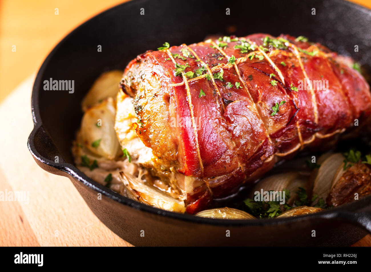 Concetto di cibo in casa pancetta di maiale ripiene al forno il filetto in  ferro padella in ghisa sulla rotonda di legno Foto stock - Alamy
