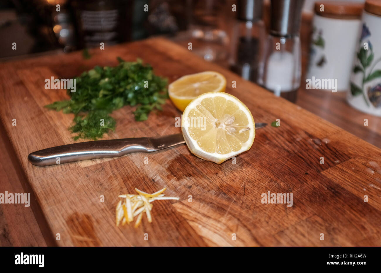 Il limone tagliato a metà con il coltello sul tagliere di legno Foto Stock