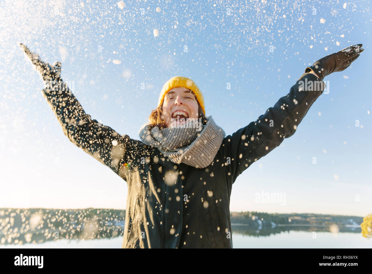 Donna gettando la neve Foto Stock