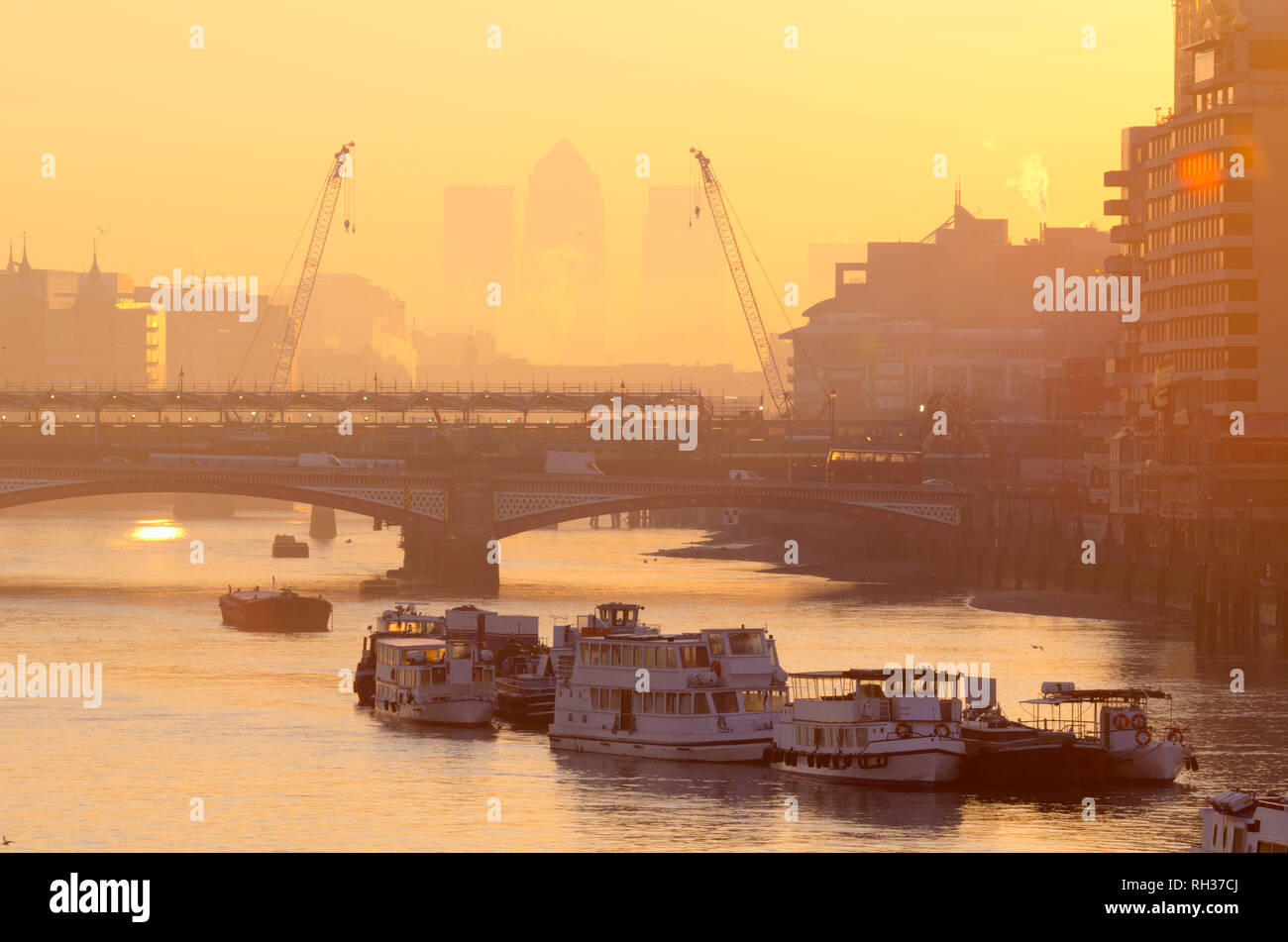 Regno Unito, Inghilterra, Londra, Canary Wharf skyline al sorgere del sole lungo il fiume Tamigi Foto Stock