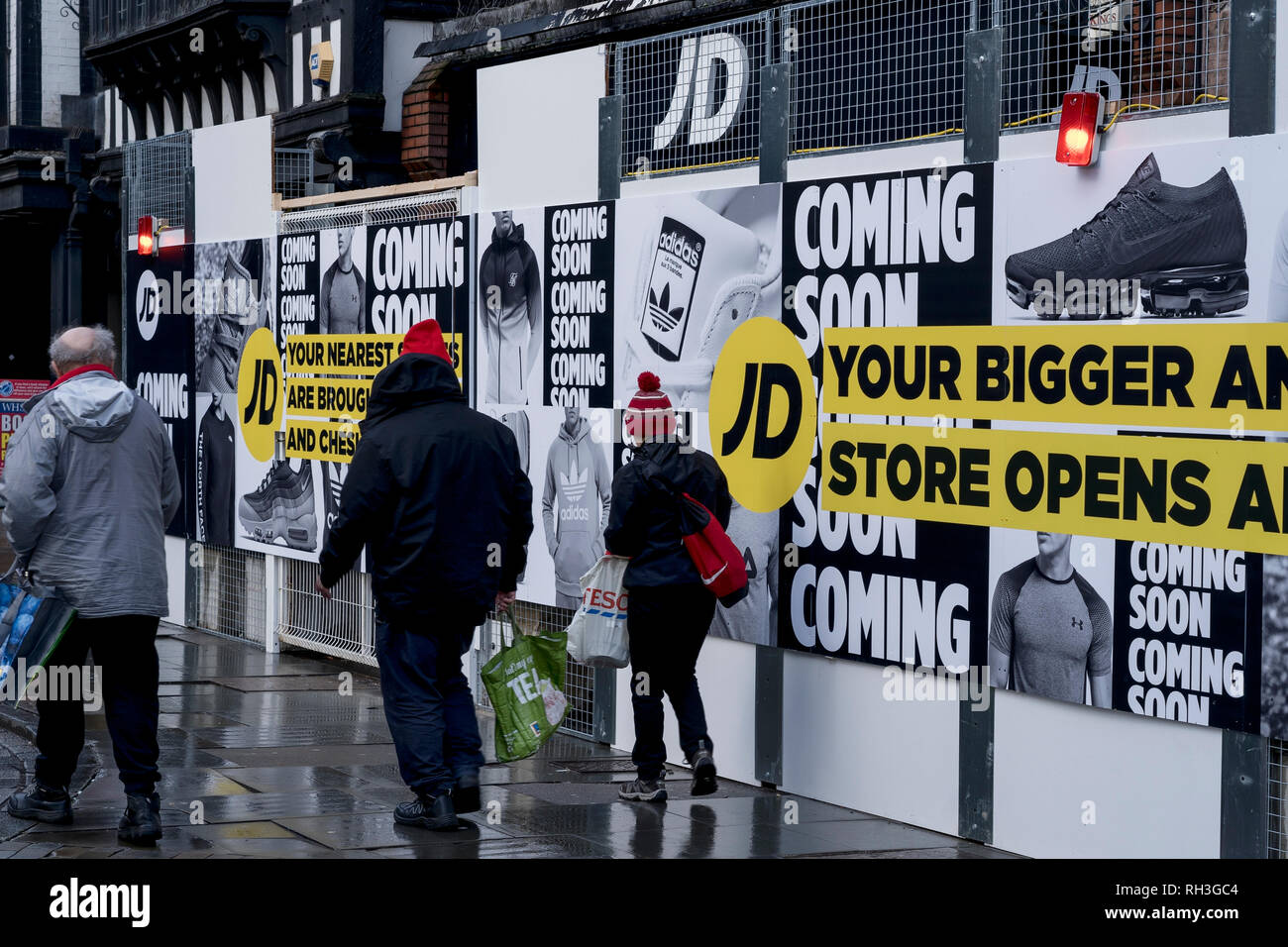 La gente camminare passato JD negozio di sport nel centro citta' di Chester che è chiusa per lavori di ristrutturazione Foto Stock
