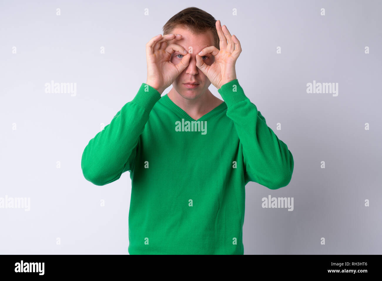 Ritratto di giovane uomo bello guardando attraverso le dita Foto Stock