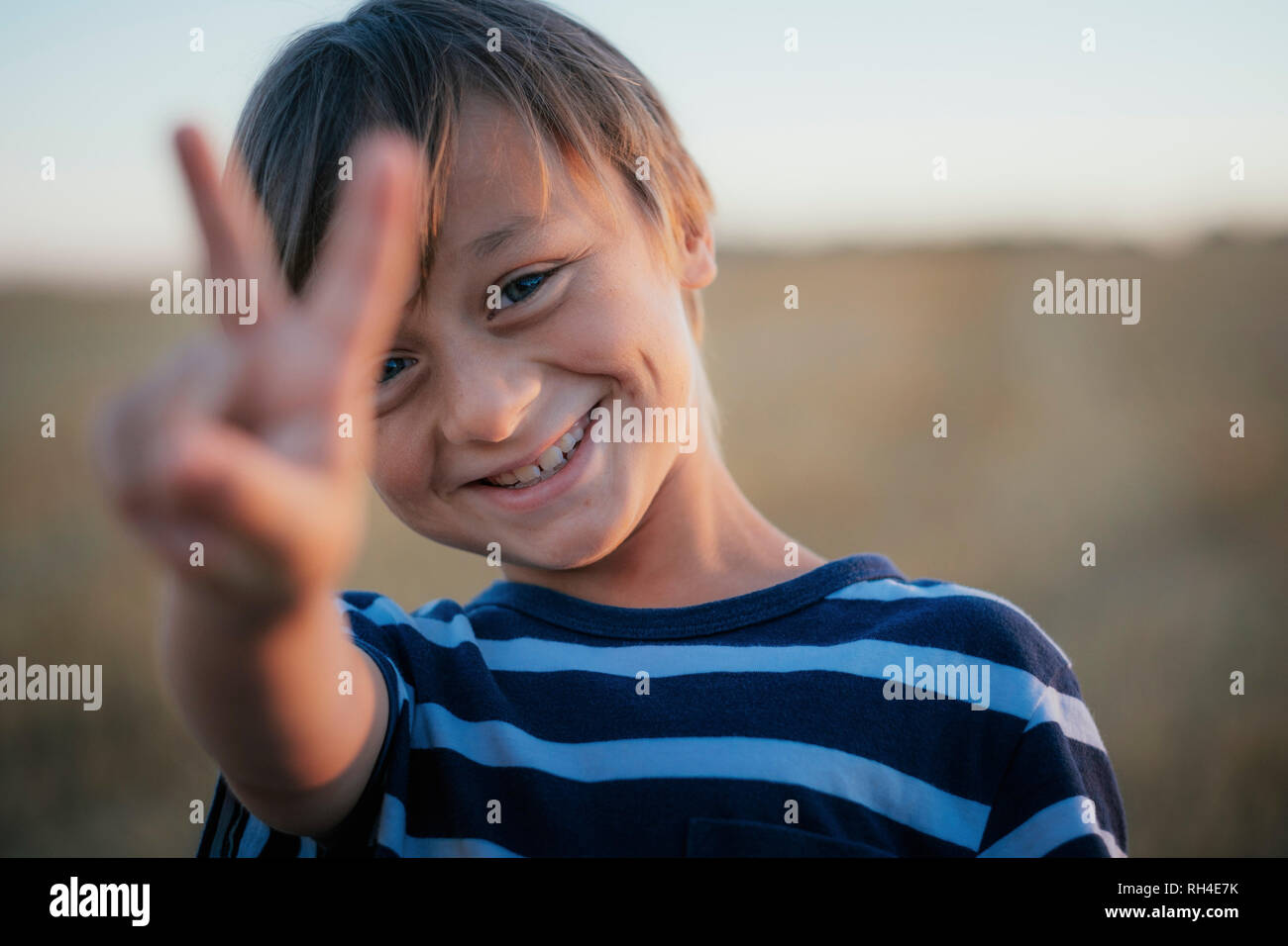 Ritratto sorridente e spensierato boy gesti segno di pace Foto Stock