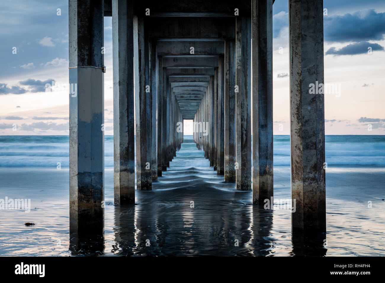 Visualizza le forme d'onda da sotto lo Scripps Pier dopo il tramonto a La Jolla, San Diego, California USA Foto Stock