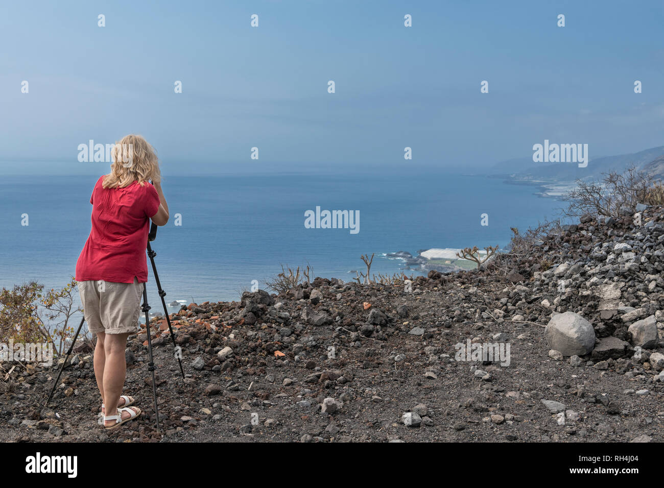 Fotografo femmina con fotocamera e treppiede prendendo immagini del paesaggio della costa del sud-ovest di La Palma Isole Canarie Spagna Foto Stock
