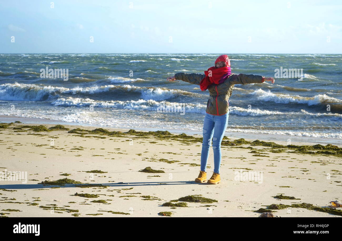 Un adolescente sfidando le alte le raffiche di vento e la sabbia di brillamento a Cape Cod beach. Foto Stock