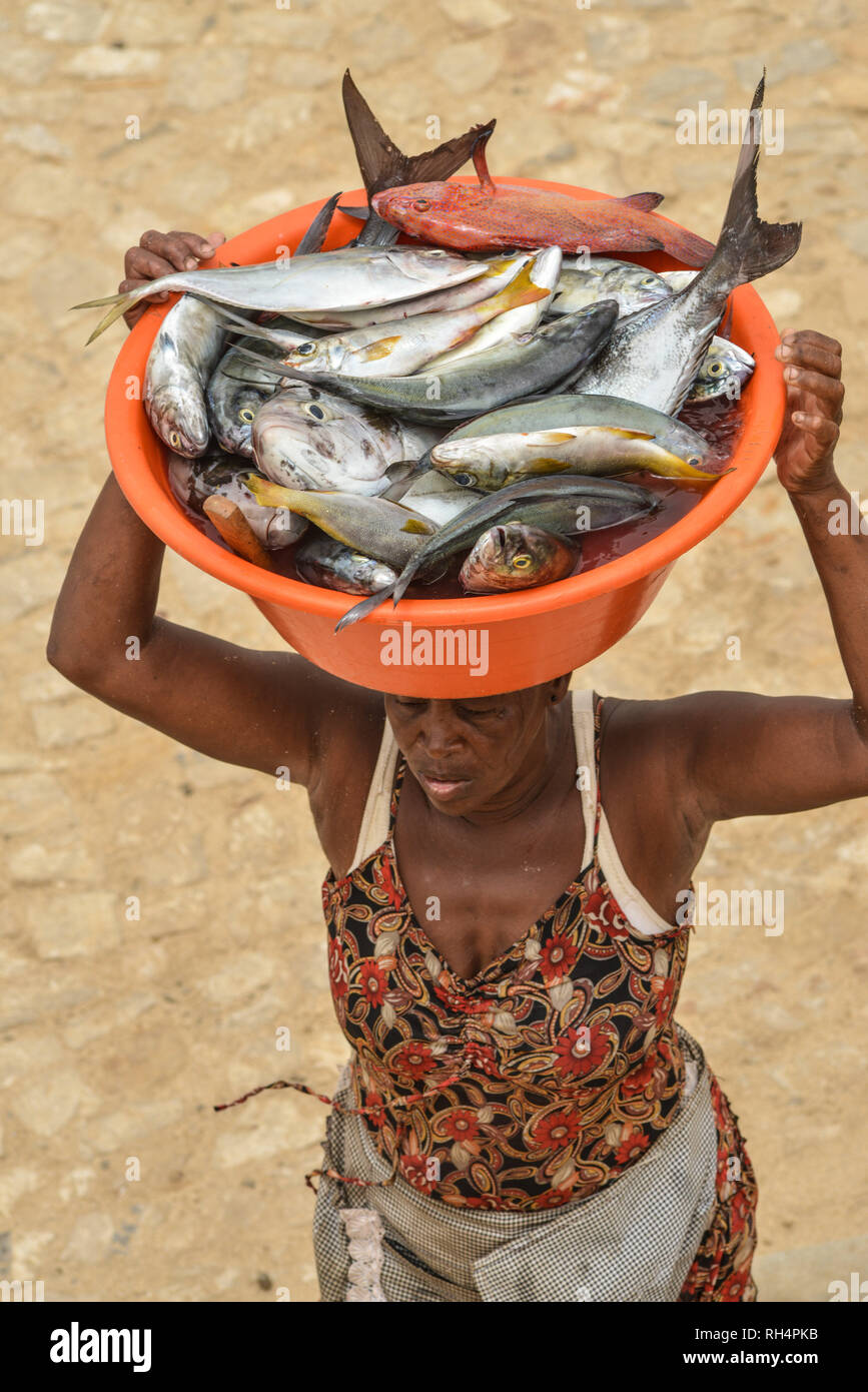 Capo Verde Isola di Maio: mercato del pesce dopo un viaggio di pesca in Vila do Maio (Porto Ingles). La donna che porta un vassoio pieno di pesce sulla sua testa e traspor Foto Stock