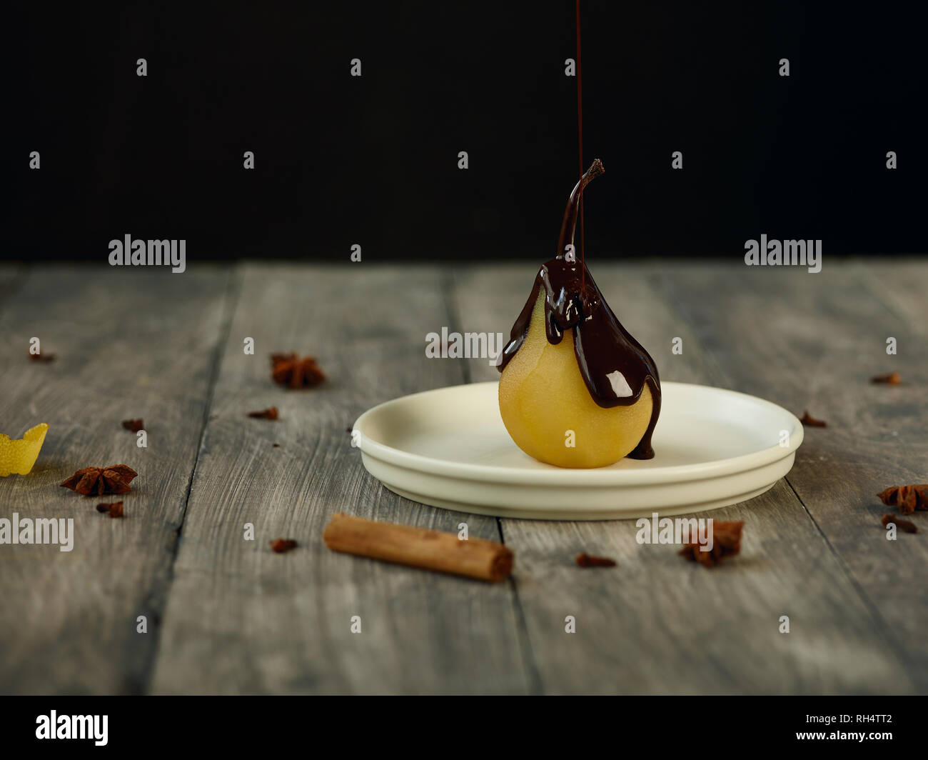 Pera affogata con salsa di cioccolato Foto Stock