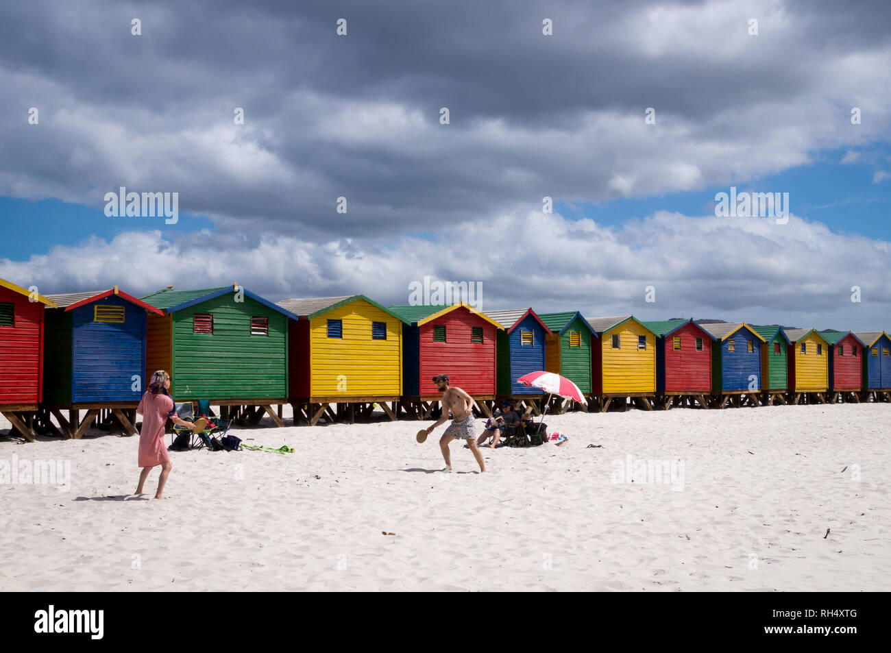 Città del Capo, Sud Africa - 9 gennaio 2019: persone che giocano a beach tennis a Muizenberg beach con le sue colorate case di balneazione. Foto Stock