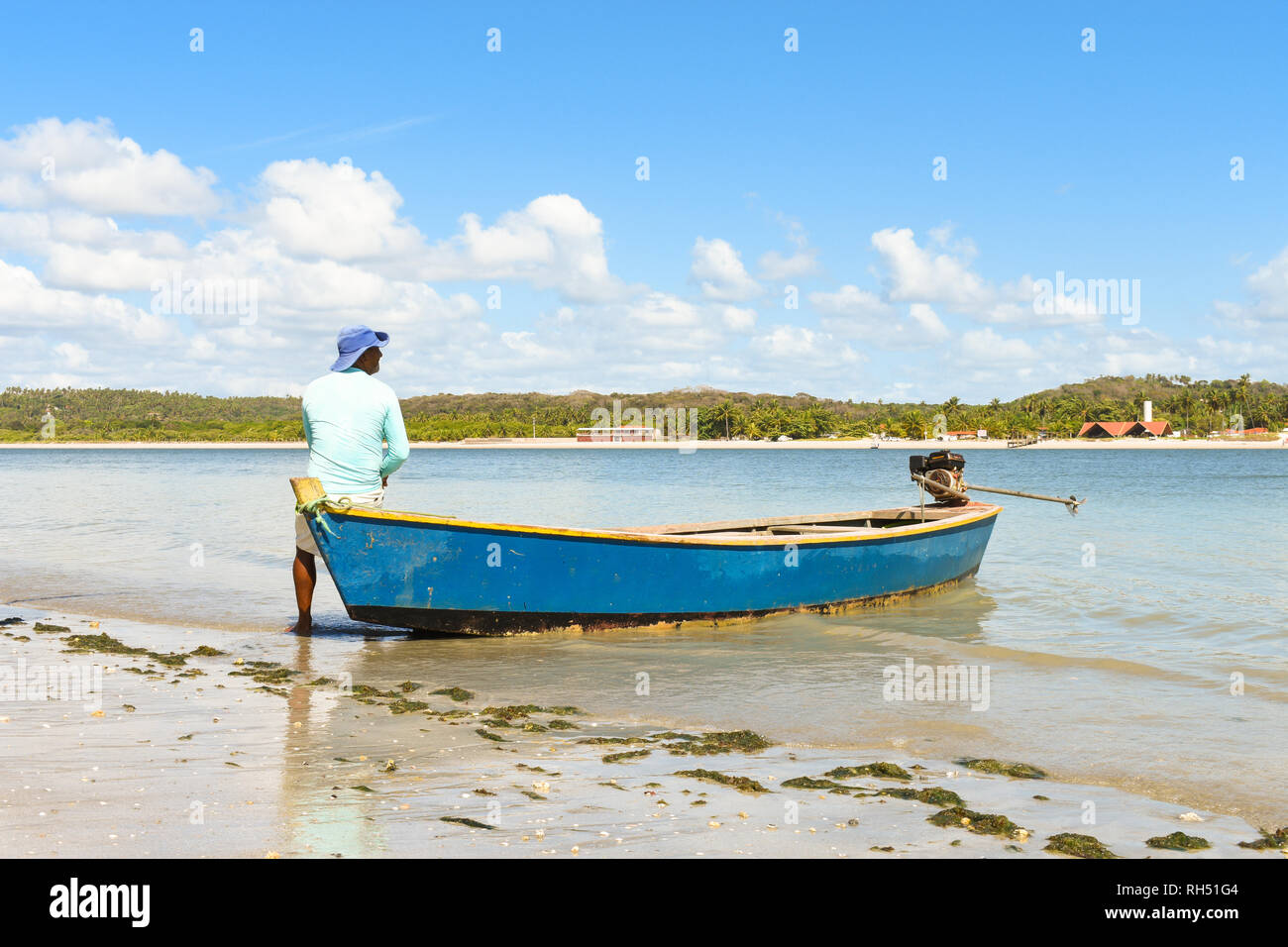 Pescatore e la sua piccola barca su Coroa do Aviao isolotto - Igarassu, Pernambuco, Brasile Foto Stock