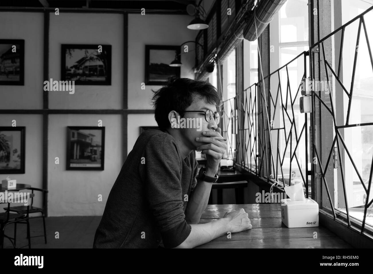 Solo l'uomo nella caffetteria in bianco e nero Foto Stock